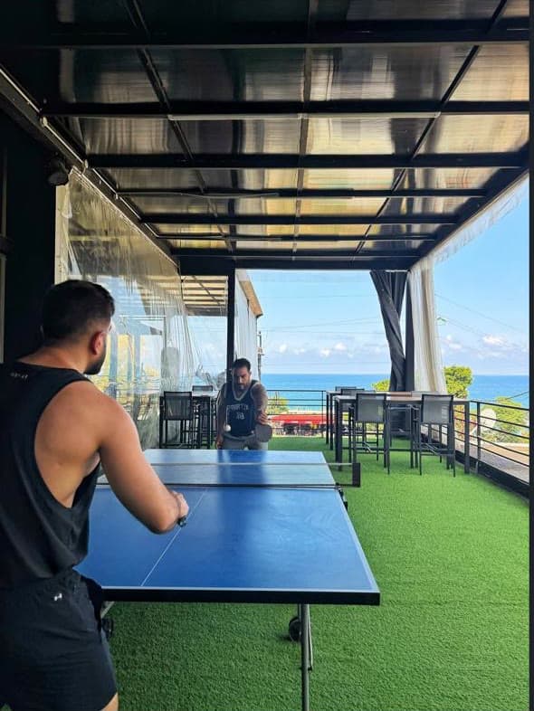 Ping-pong on the terrace with the sea behind